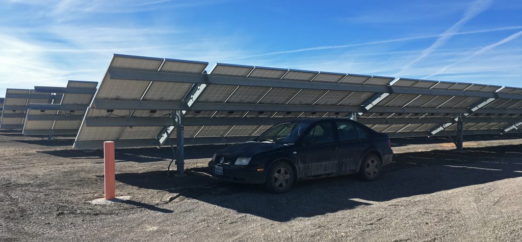 A sedan is parked in the shadow of solar photovoltaic panels at the Stillwater power plant near Fallon, Nevada