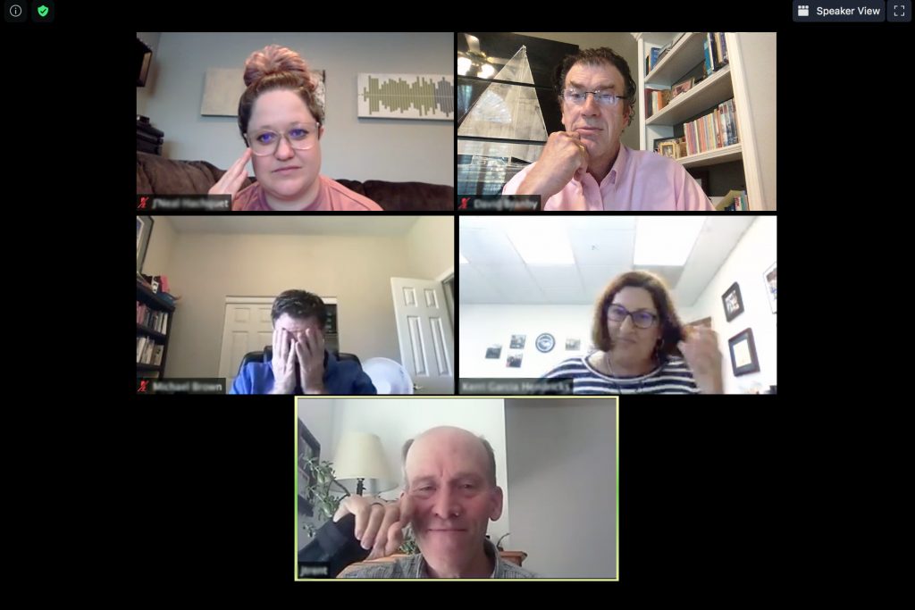 People touching their face while participating in a Zoom online meeting
