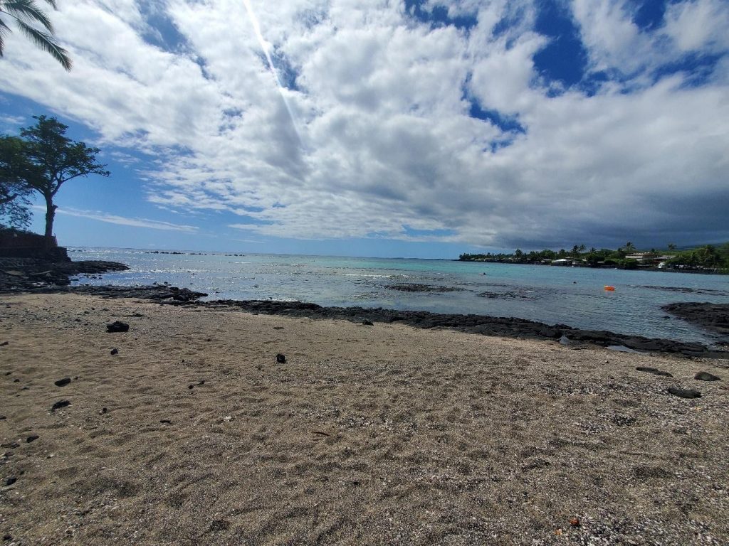 Photo of the beach at Kahaluu Bay. The beach is completely vacant.