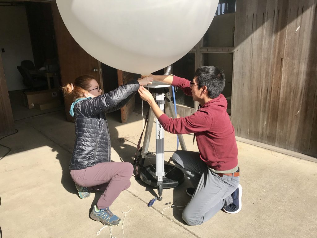 Research Ava Cooper and a teammate work on setting up a weather balloon, which is about a meter in diameter.