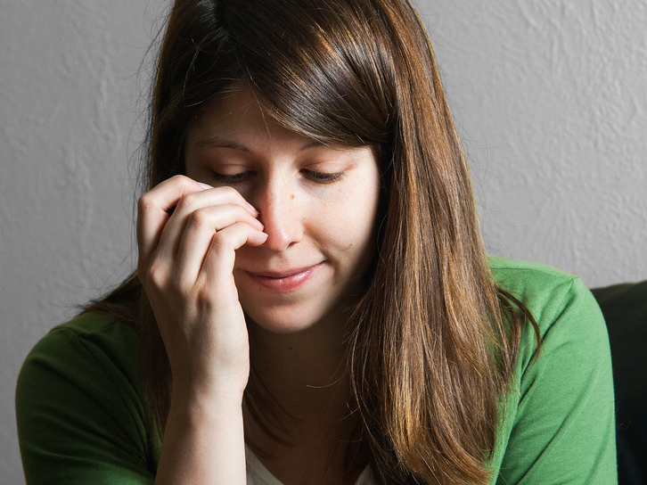 A woman scratches her nose