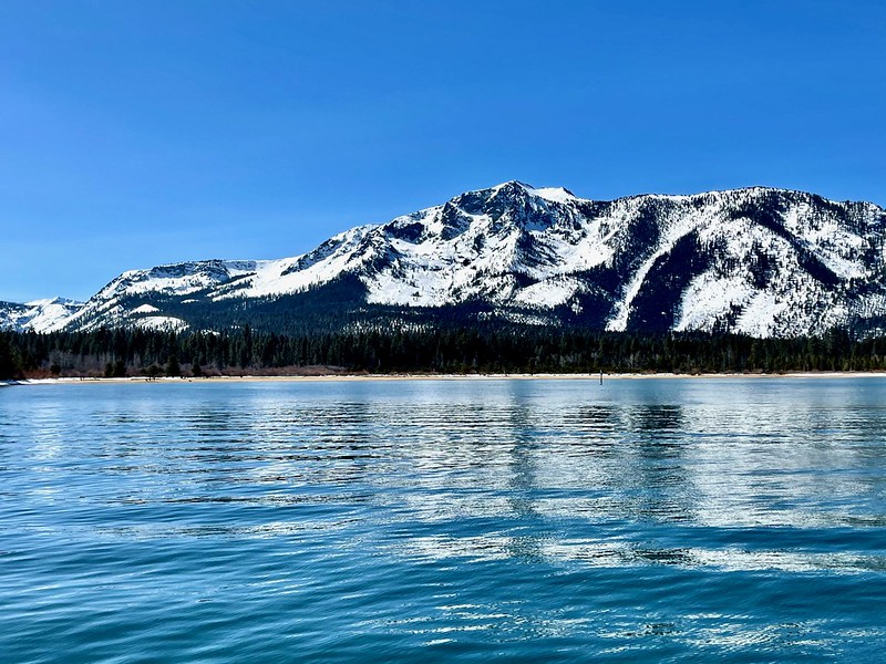 A picture of Lake Tahoe with snow-topped mountains in the background.