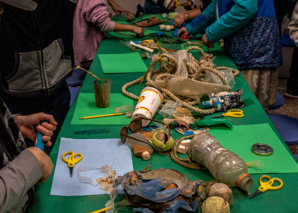 bottles, ropes, and other trash that was pulled out of Lake Tahoe sits on table with green tablecloth