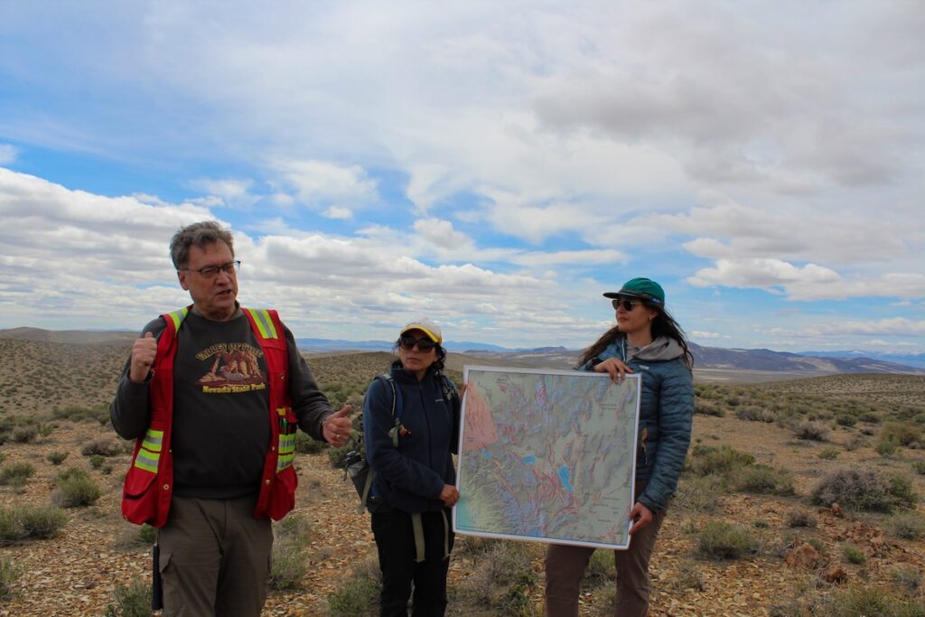Professor Faulds explained geothermal features to his students while Professor Carolina Muñoz-Saez and one student hold a map.