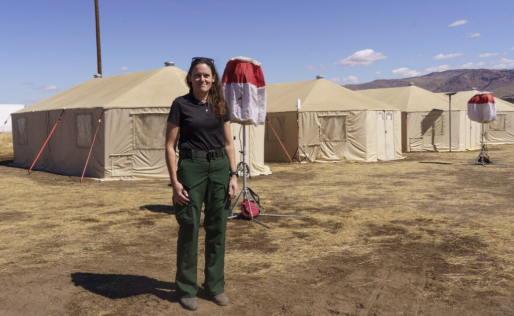 Marya Washburn stands in front of tents acting as offices at Davis fire incident command in South Reno.