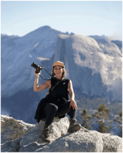 Hannah Truby holding a camera during a hike in Yosemite National Park.