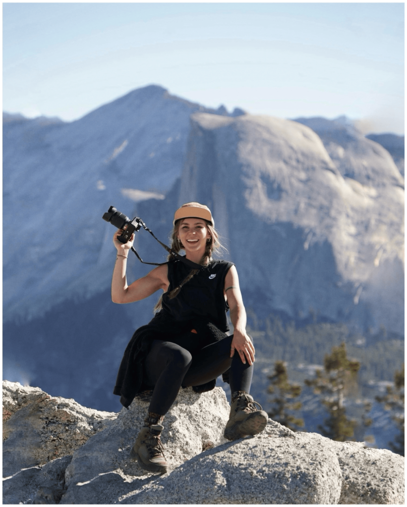 Hannah Truby holding a camera during a hike in Yosemite National Park.