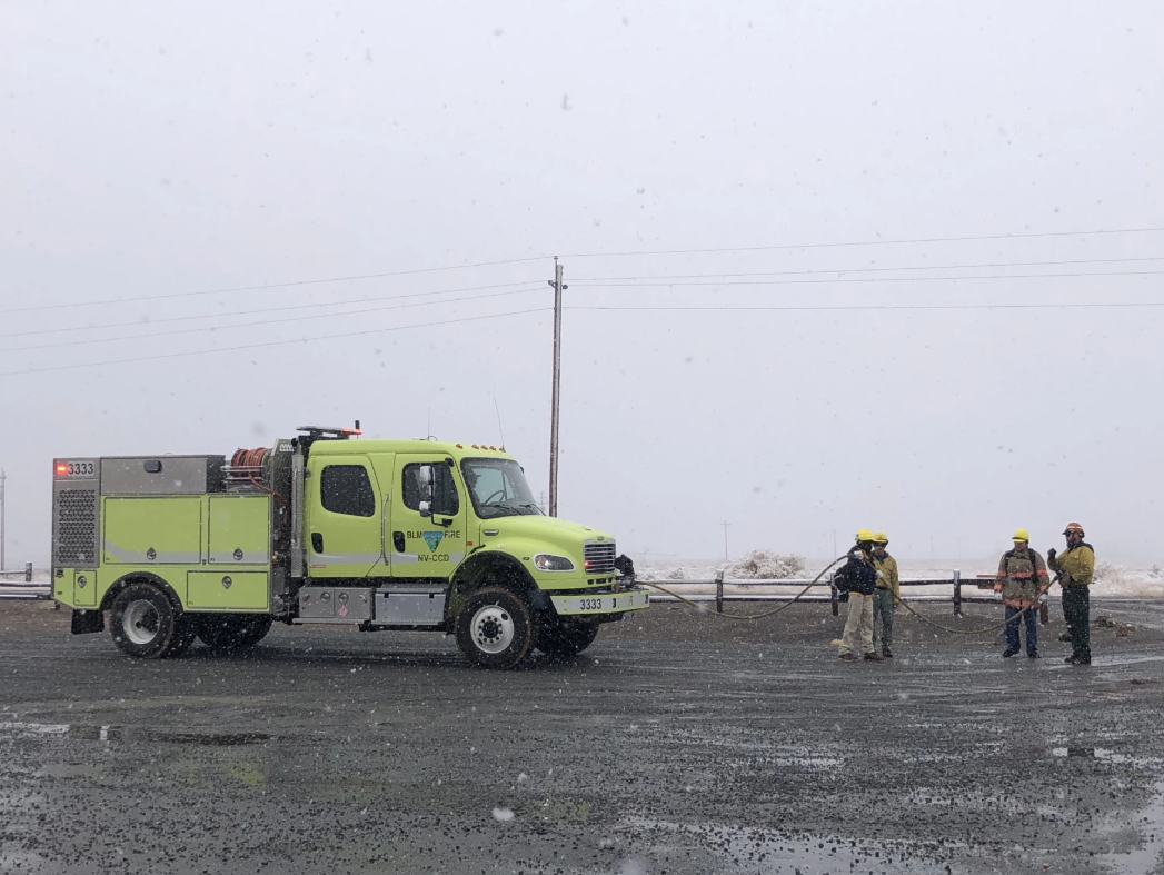 green blm fire engine and a group of students