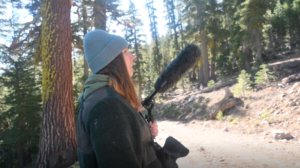 Sofia Haley stands in forest with microphone