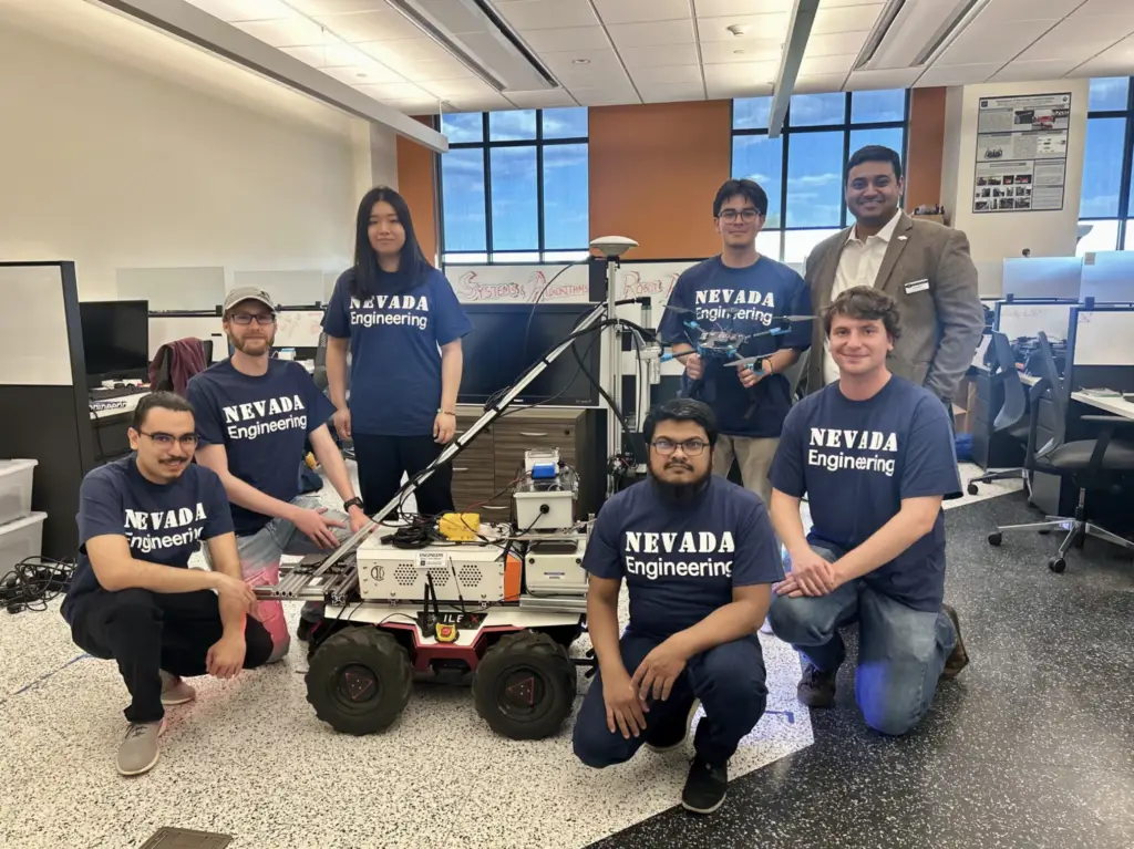 Roboticist Parikshit Maini, standing on the right, poses with his team, comprised of undergraduate and graduate students, in the SARAL lab. They are standing next to the MoistureMapping robot, which will be the base for the RoboHydra.