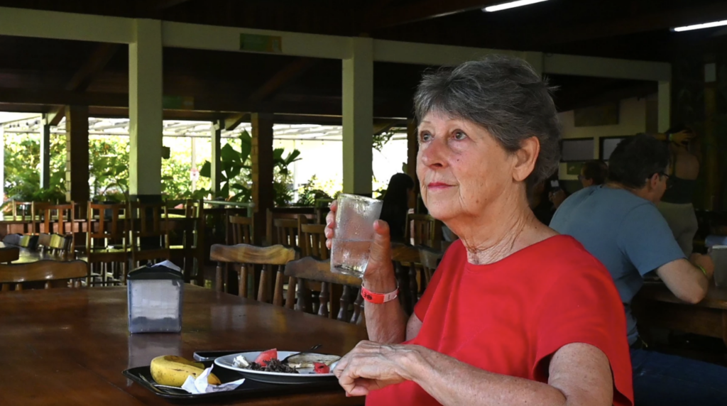 Katherine Grall sits at the La Selva cafeteria looking at the tree outside the dining area.
