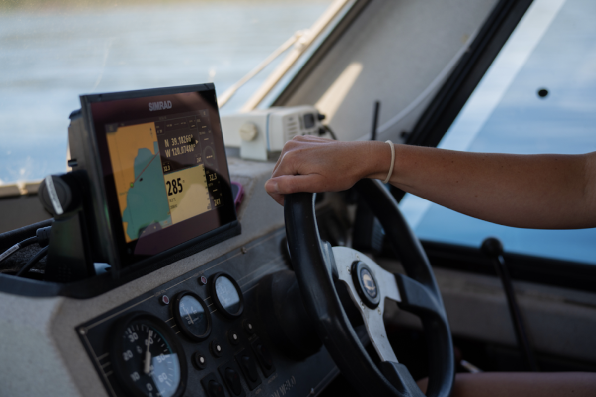 hand on steering wheel of boat